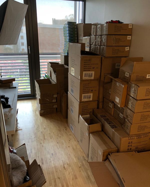 Ein Wohnzimmer voller gestapelter Versandkartons, die Anfänge des ersten Online-Shops